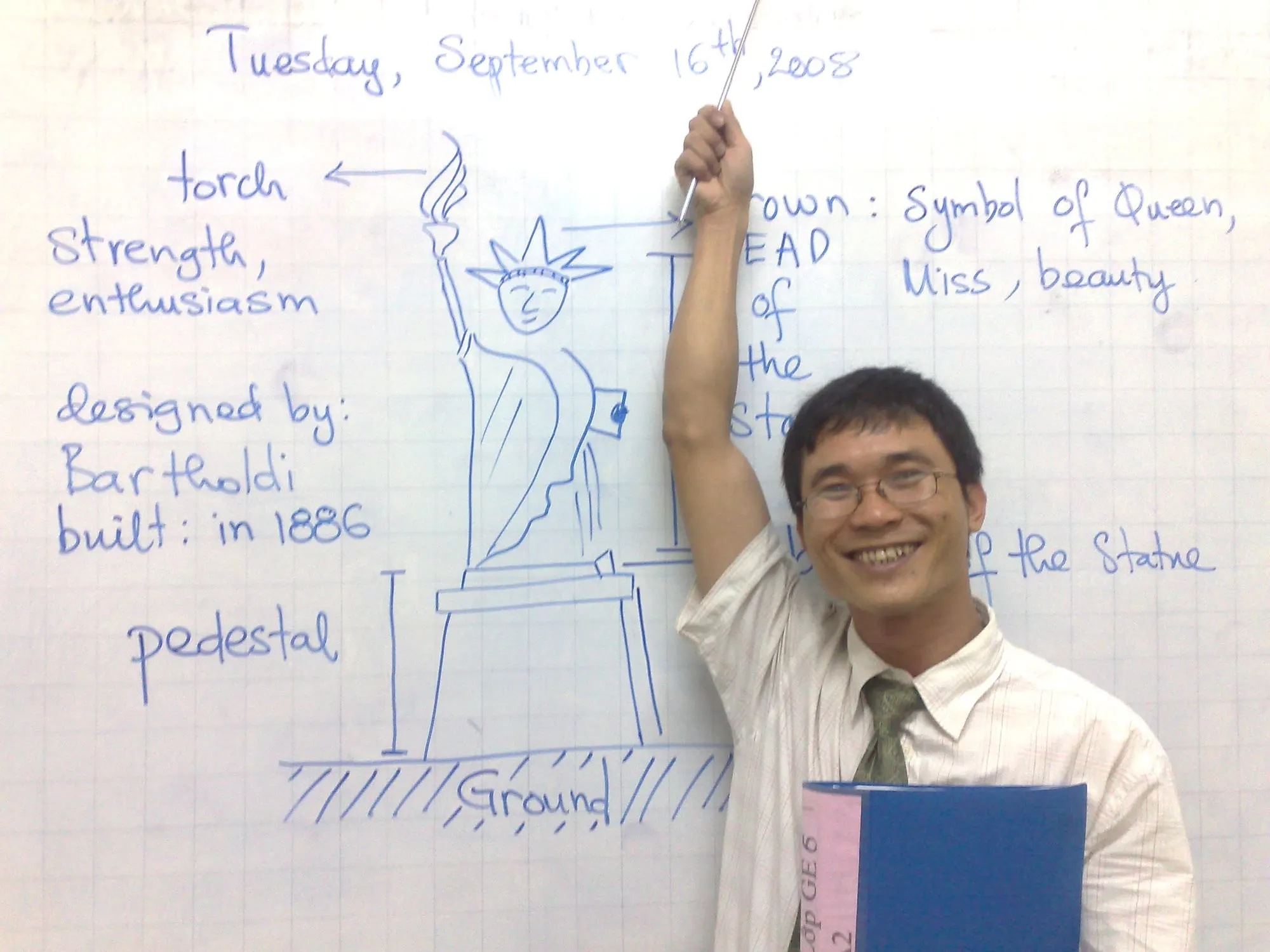 Thầy giáo tiếng Anh mỉm cười bên bảng trắng trong giờ học